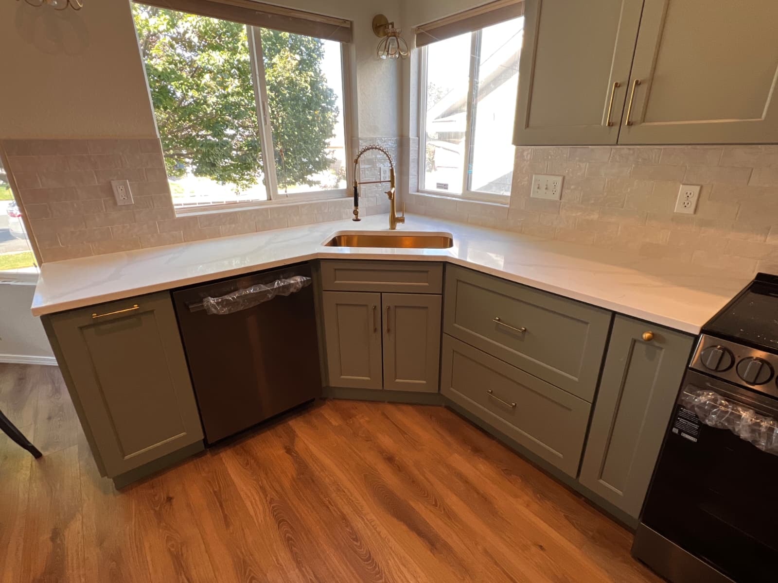 Sage shaker cabinetry and brass hardware in Colorado Springs kitchen renovation